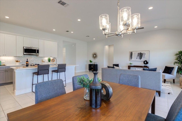 dining space with light tile patterned floors, recessed lighting, visible vents, and a chandelier