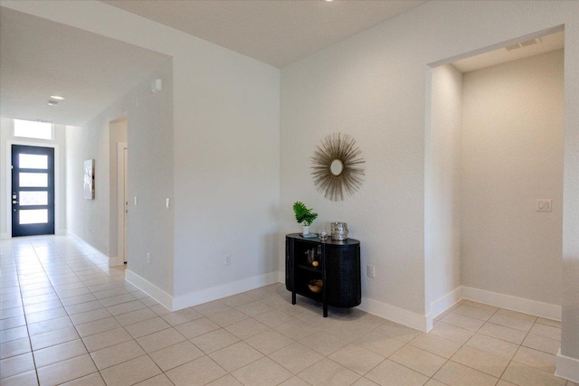 corridor with light tile patterned floors and baseboards