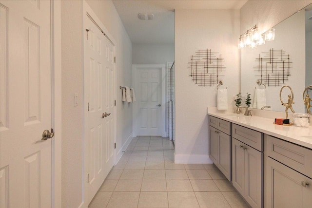 full bathroom featuring tile patterned floors, a sink, baseboards, and double vanity