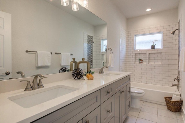 full bathroom with a sink, toilet, double vanity, and tile patterned flooring