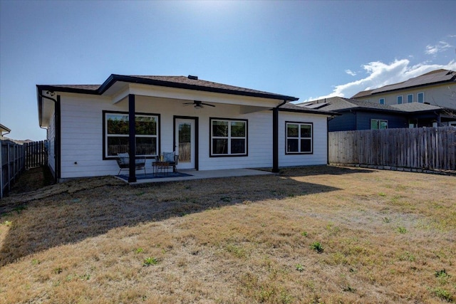 rear view of house with a fenced backyard, a lawn, a patio, and ceiling fan