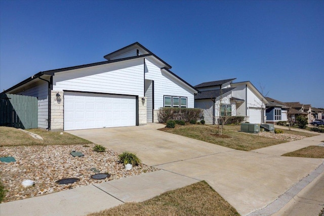 view of front of property featuring a garage, stone siding, and driveway