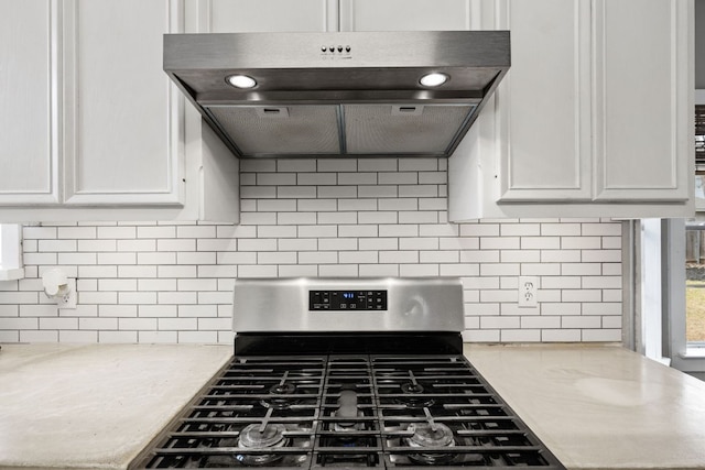 kitchen with light countertops, white cabinets, exhaust hood, and stainless steel gas range oven