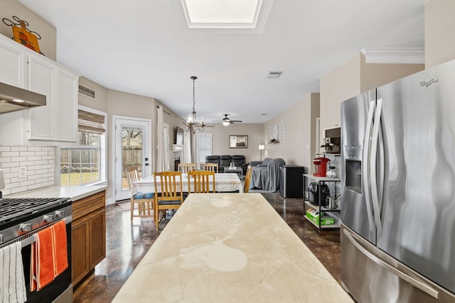 kitchen featuring visible vents, stainless steel appliances, light countertops, concrete flooring, and backsplash