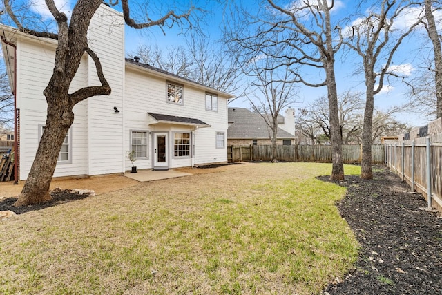 rear view of house featuring a patio, a lawn, and a fenced backyard