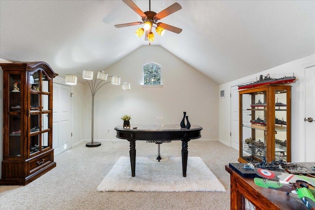 carpeted home office featuring baseboards, visible vents, lofted ceiling, ceiling fan, and a textured ceiling