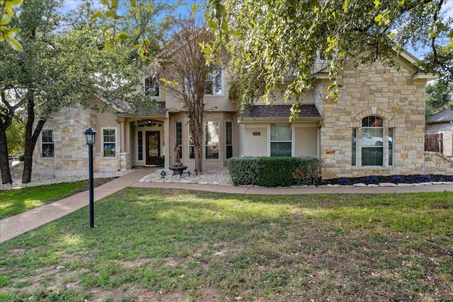 view of front of property with stucco siding, stone siding, and a front lawn