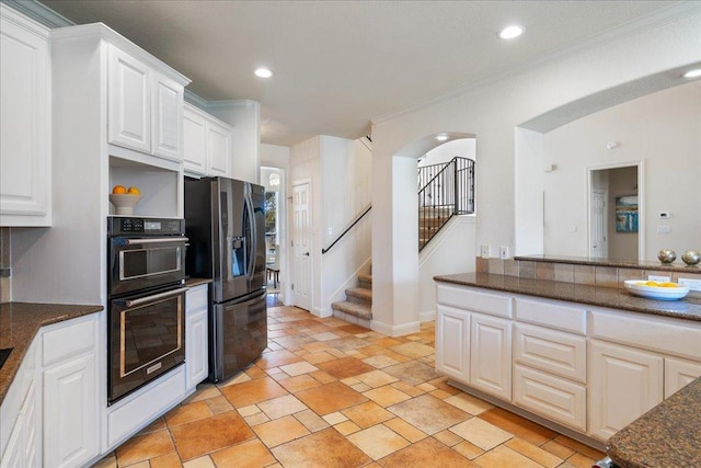 kitchen with ornamental molding, black fridge, white cabinetry, recessed lighting, and arched walkways