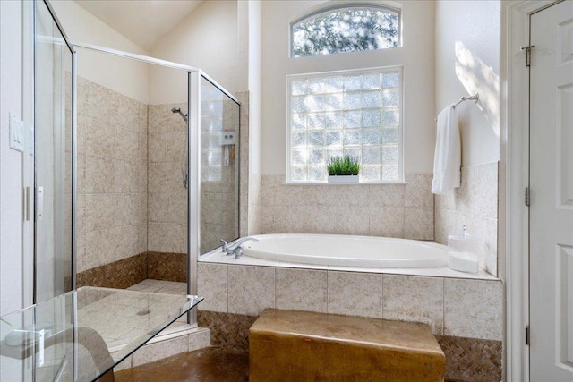 full bath with lofted ceiling, a garden tub, and a shower stall