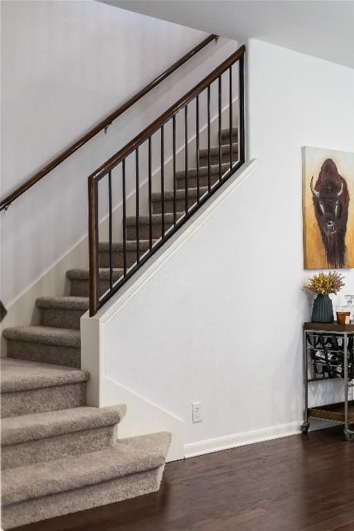 staircase featuring baseboards and wood finished floors