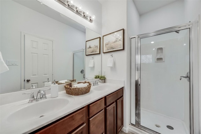 full bathroom with a sink, double vanity, and a shower stall