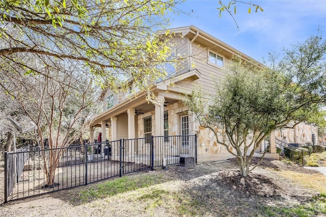 view of side of home featuring a patio, a ceiling fan, and fence