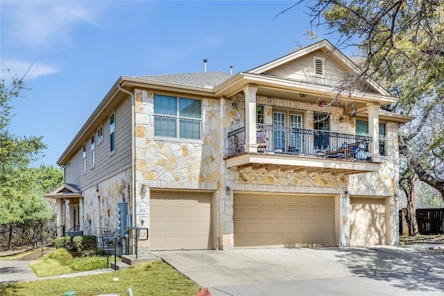 view of front of property featuring stone siding, a garage, concrete driveway, and a balcony