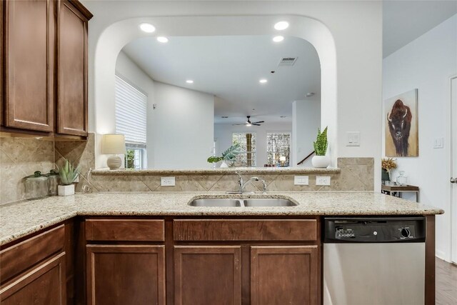 kitchen with visible vents, arched walkways, a sink, decorative backsplash, and stainless steel dishwasher