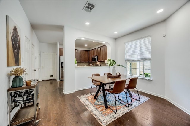 dining space with visible vents, baseboards, recessed lighting, arched walkways, and dark wood-style floors