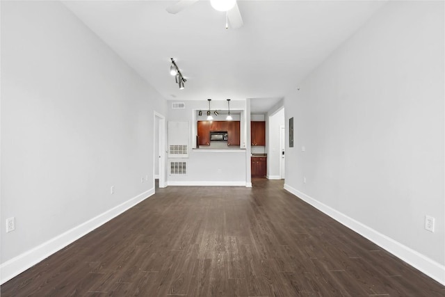 unfurnished living room with dark wood-type flooring, baseboards, and ceiling fan