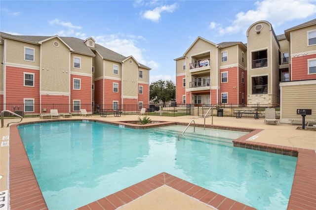 pool with a patio and fence