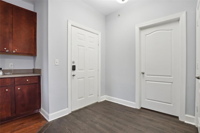 interior space featuring dark wood-type flooring and baseboards