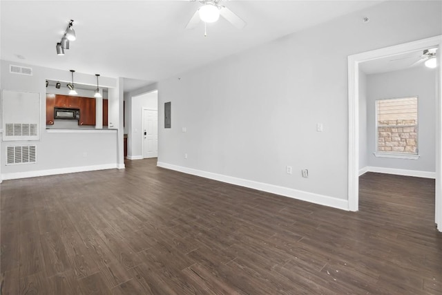 unfurnished living room with baseboards, visible vents, dark wood-style flooring, and ceiling fan