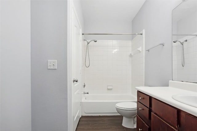 bathroom featuring shower / washtub combination, toilet, vanity, and wood finished floors