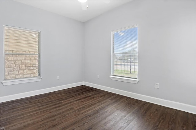 unfurnished room featuring baseboards, dark wood-type flooring, and a ceiling fan