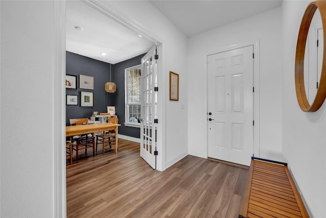 foyer entrance with french doors, baseboards, and wood finished floors