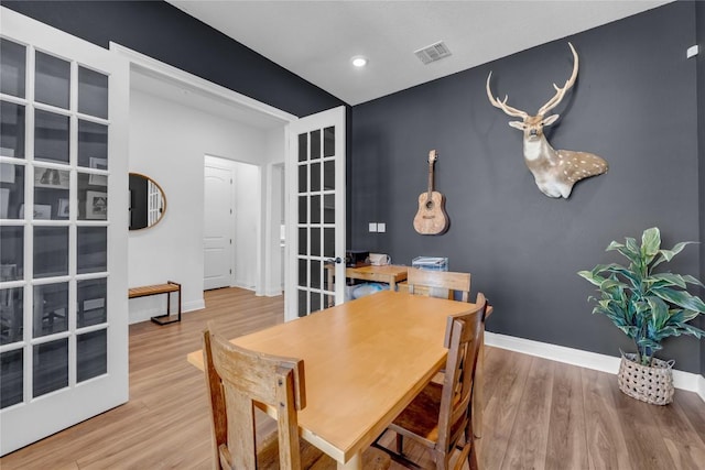 dining room featuring wood finished floors, visible vents, baseboards, recessed lighting, and french doors