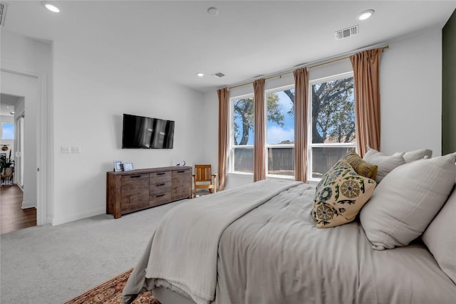 carpeted bedroom with multiple windows, recessed lighting, and visible vents