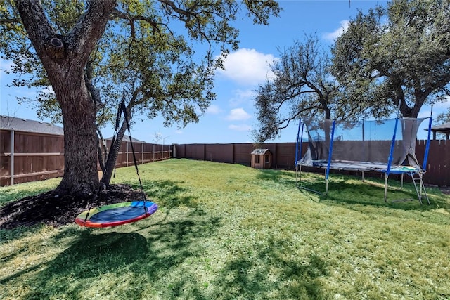 view of yard featuring a trampoline and a fenced backyard