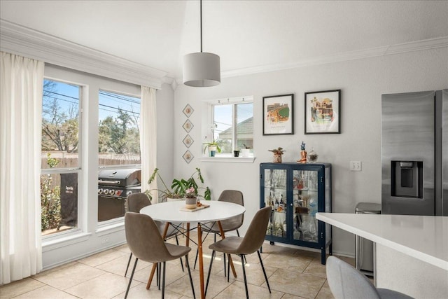 dining area featuring light tile patterned floors and ornamental molding