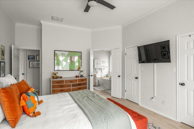 bedroom featuring light wood-type flooring, visible vents, ensuite bath, and crown molding