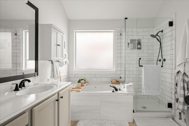 full bath with a wealth of natural light, a stall shower, vanity, and a bath