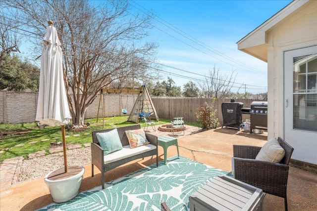 view of patio featuring grilling area, an outdoor fire pit, and a fenced backyard