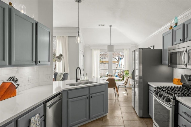 kitchen with visible vents, gray cabinets, a sink, ornamental molding, and stainless steel appliances