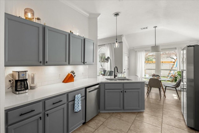 kitchen with a sink, appliances with stainless steel finishes, gray cabinets, and crown molding