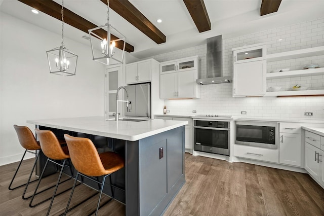 223 Honey Creek Ct Unit 12, Lakeway, TX 78738 - kitchen featuring appliances with stainless steel finishes, wall chimney range hood, beam ceiling, decorative backsplash, and white cabinetry