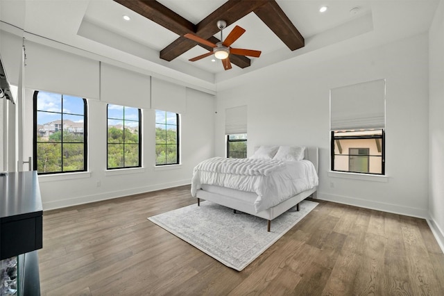 bedroom with baseboards, coffered ceiling, beam ceiling, and wood finished floors