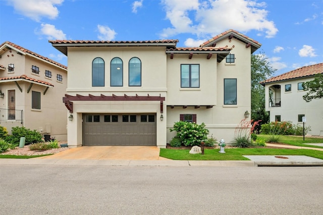 mediterranean / spanish home with stucco siding, a garage, concrete driveway, and a tile roof