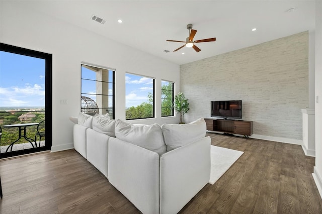 living area with dark wood-type flooring, baseboards, visible vents, and ceiling fan