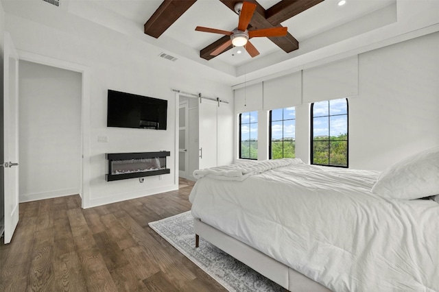 bedroom with visible vents, beamed ceiling, wood finished floors, recessed lighting, and a barn door