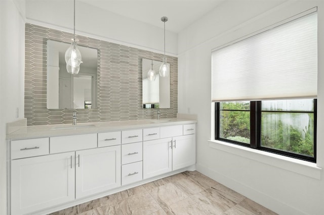 full bathroom featuring a sink, baseboards, marble finish floor, and double vanity