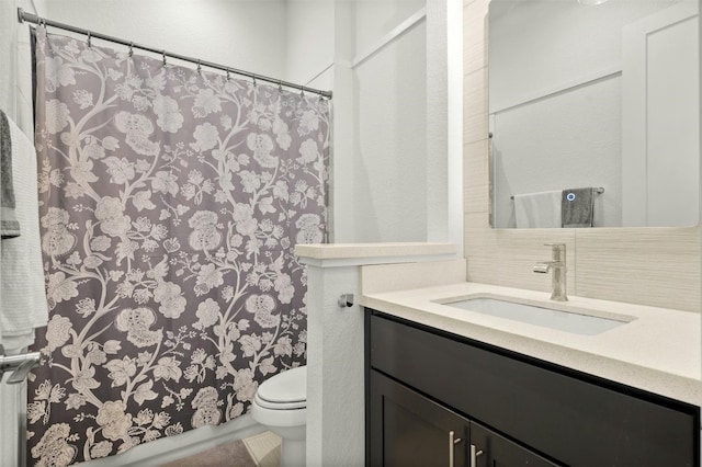 bathroom with tasteful backsplash, curtained shower, toilet, and vanity