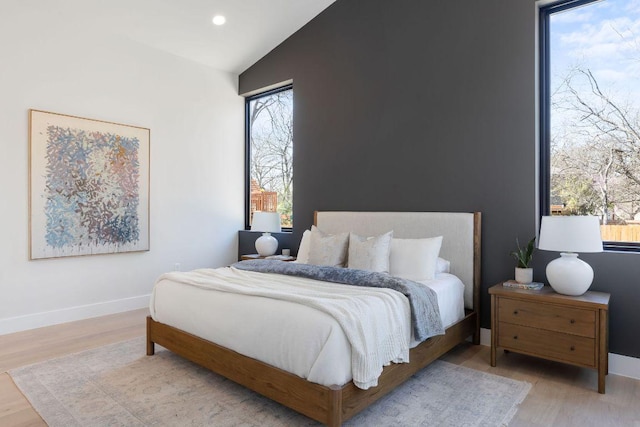 bedroom featuring lofted ceiling, recessed lighting, wood finished floors, and baseboards