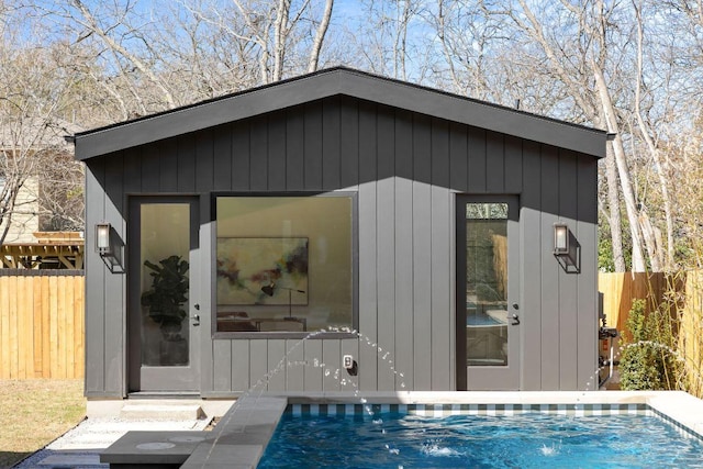 view of outbuilding featuring a fenced in pool, an outbuilding, and fence