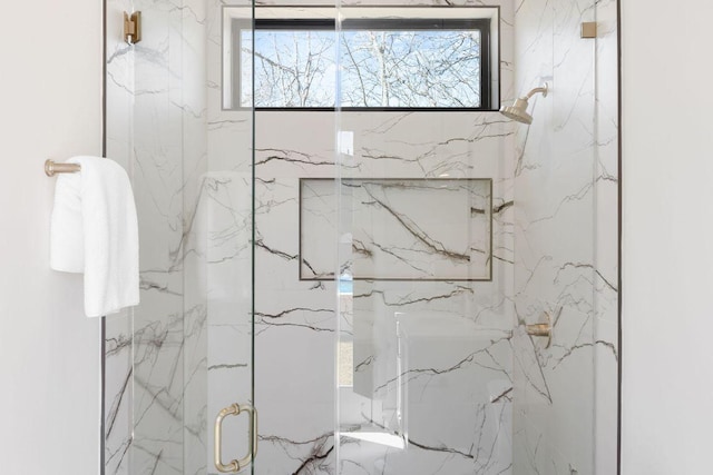 bathroom featuring a marble finish shower