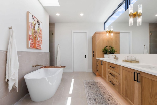 bathroom with tile patterned flooring, double vanity, a tile shower, a skylight, and a freestanding tub