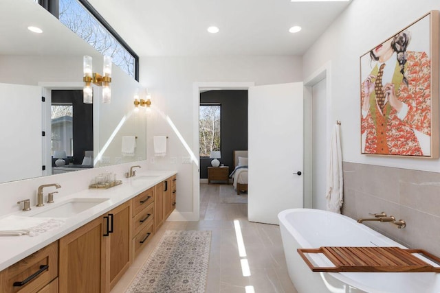 5514 Montview St, Austin, TX 78756 - ensuite bathroom featuring double vanity, healthy amount of natural light, a freestanding tub, recessed lighting, and tile patterned floors