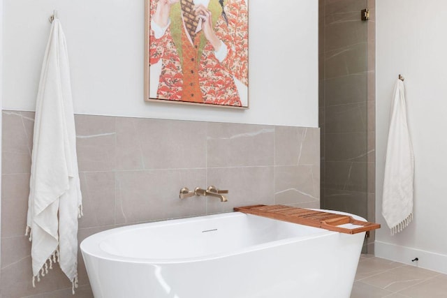 bathroom with a freestanding bath and tile walls