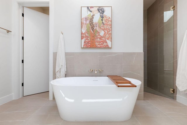 full bathroom with tile patterned flooring, a soaking tub, and tile walls