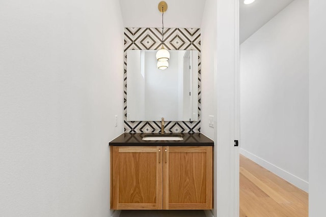 bathroom with baseboards, wood finished floors, and vanity